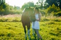 Teenager girl in white dress with horse in the field Royalty Free Stock Photo