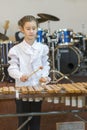 Teenager girl in a white shirt boy playing the marimba. Vertical photo