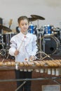 Teenager girl in a white shirt boy playing the marimba. vertical photo