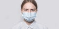 Teenager girl 12-13 years old, face covered with medical mask, close-up portrait, chagrin and serious look, tired and