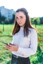 Teenager girl 12-15 years old portrait, in summer city, in hand smartphone, outdoor recreation after lessons in college Royalty Free Stock Photo