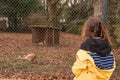 Teenager girl in yellow jacket looking at sleeping cheetah in a zoo. Learning nature concept. Kid study predator
