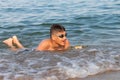 Teenager in goggles swims in the sea with big splashes. Cute boy enjoys swimming in the ocean. Holidays  vacation with kids Royalty Free Stock Photo