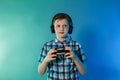 Teenager goy with headphones on his head with a joystick playing