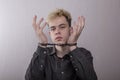 A teenager in handcuffs on a gray background. juvenile delinquents in quarantine, criminal liability. Members of youth criminal gr