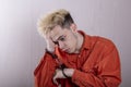 A teenager in handcuffs holds his head with his hands on a gray background. Headache for juvenile delinquents in quarantine, Royalty Free Stock Photo