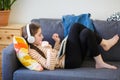 Teenager with headphones on lies on couch and listens to music. girl with tablet