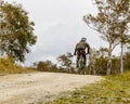 A teenager in a helmet on a mountain bike climbs up a forest road