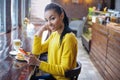 Teenager with her cell phone in bakery Royalty Free Stock Photo