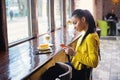 Teenager with her cell phone in bakery Royalty Free Stock Photo