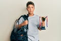 Teenager hispanic boy holding sport bag holding trophy depressed and worry for distress, crying angry and afraid