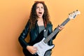 Teenager hispanic girl playing electric guitar angry and mad screaming frustrated and furious, shouting with anger looking up Royalty Free Stock Photo