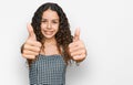 Teenager hispanic girl wearing casual clothes approving doing positive gesture with hand, thumbs up smiling and happy for success Royalty Free Stock Photo