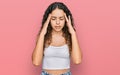 Teenager hispanic girl wearing casual clothes with hand on head for pain in head because stress