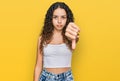 Teenager hispanic girl wearing casual clothes looking unhappy and angry showing rejection and negative with thumbs down gesture Royalty Free Stock Photo