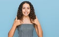 Teenager hispanic girl wearing casual clothes success sign doing positive gesture with hand, thumbs up smiling and happy Royalty Free Stock Photo