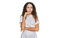 Teenager hispanic girl wearing casual white t shirt serious face thinking about question with hand on chin, thoughtful about Royalty Free Stock Photo