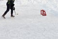 Teenager with hockey stick, wearing ice-skating, skates with puck, plans to shoot at little training red goal Active sport outdoor