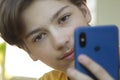 Teenager Holded in Hand Smartphone . Boy look in cell phone and take picture