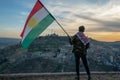 Teenager holding the Kurdistan flag in northern Iraq at sunset time