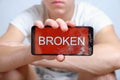 Teenager holds in hand mobile device with broken touchscreen