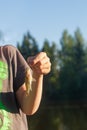 A teenager holds a small fish on a hook on a fishing line in the summer by the river. Royalty Free Stock Photo