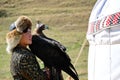 Almaty / Kazakhstan - 09.23.2020 : A teenager in a Kazakh national costume holds a tamed Golden eagle in his hands