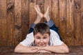 Teenager lying on his stomach. Against the background of the wooden planks Royalty Free Stock Photo