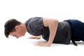 Teenager making push ups in jeans and t-shirt isolated on white