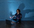 Teenager man suffering Internet cyber bullying sitting alone with computer feeling hopeless