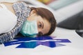 Teenager with mask with her head lying on an ambulance hood Royalty Free Stock Photo