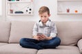 Teenager messaging online on smartphone in living room at home