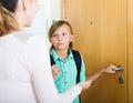 Teenager and mother staying near flat entrance