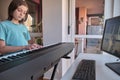 Teenager musician playing classic digital piano at home during online class at home, social distance during quarantine Royalty Free Stock Photo