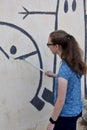 Teenage girl repairs wallpainting