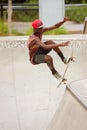 Teenager Performs Jump While Practicing Skateboarding At Skateboard Park