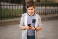 Teenager play games at mobile phone outside Royalty Free Stock Photo
