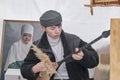 Teenager play kazakh folk musical instrument, dombra during festival Nowruz, Almaty, Kazakhstan Royalty Free Stock Photo