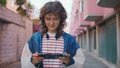 Teenager playing handheld console walking urban area. Woman focused on display Royalty Free Stock Photo