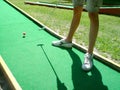 Teenager playing outdoor mini golf with copy space for your text