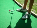 Teenager playing outdoor mini golf with copy space for your text