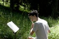 Teenager playing transverse flute in a wood with copy space for your text