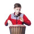 Teenager plays the djembe in studio with white background Royalty Free Stock Photo