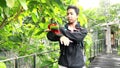 Teenager plays with Red Lory parrot in the bird park. Red Lory sitting on a hand in the Park. Close Up of Molluscan Lory