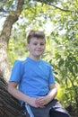 A teenager poses for a photographer while walking in the park.