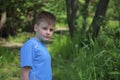 A teenager poses for a photographer while walking in the park.