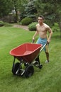 Teenager pushing wheelbarrow Royalty Free Stock Photo