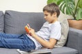 Teenager with rainbow pop-it fidget toy at home. Sad tired kid playing with trendy stress and anxiety relief fidgeting Royalty Free Stock Photo