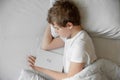 The teenager sleeps in bed. He fell asleep with the book Royalty Free Stock Photo