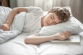 The teenager sleeps in bed. He fell asleep with the book Royalty Free Stock Photo